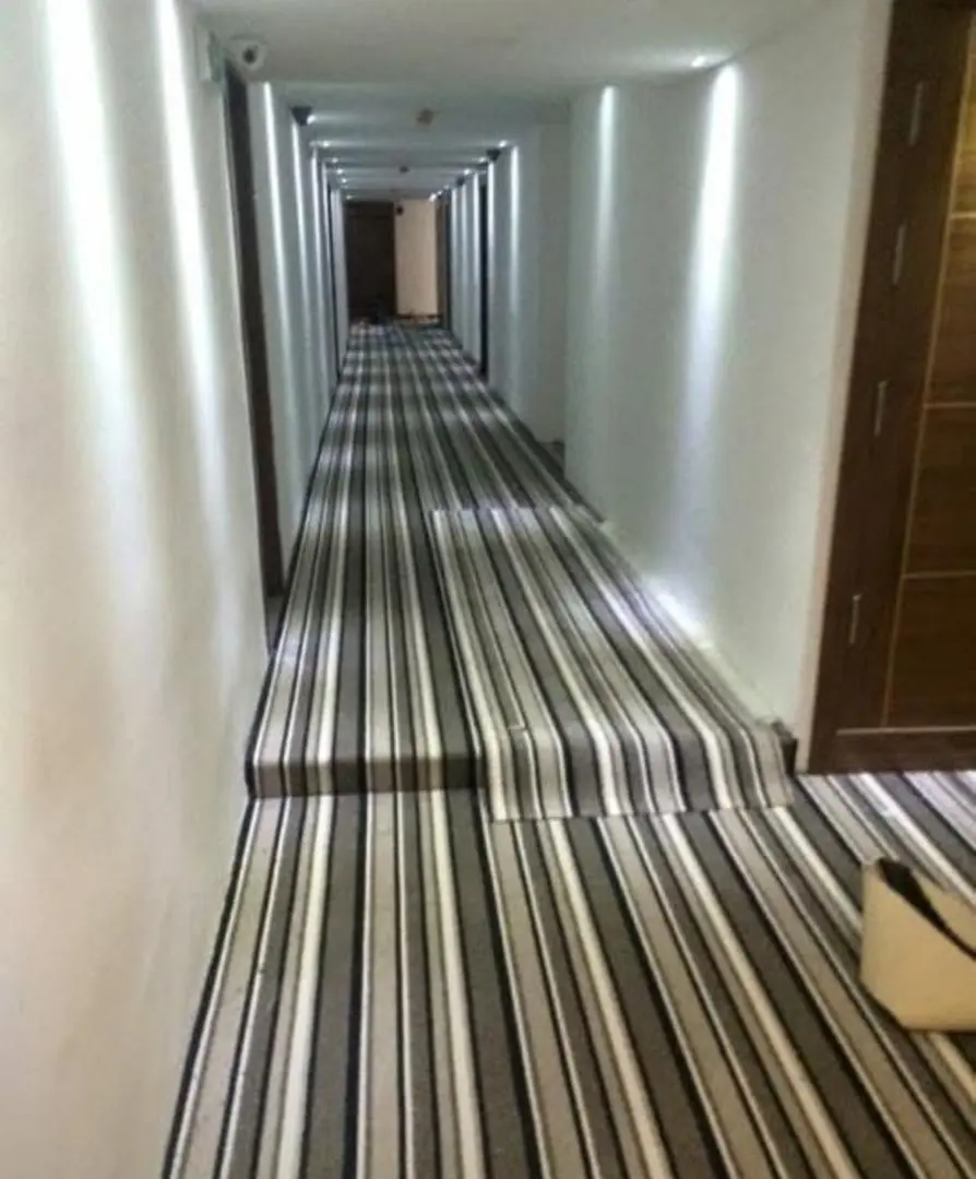 Moquette rayée posée dans un couloir d'hôtel, avec reprise sur les marches